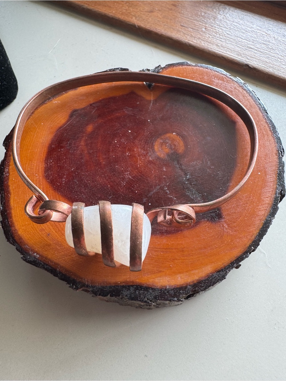 hand-forged artisan copper wire bangle featuring a raw quartz crystal cente